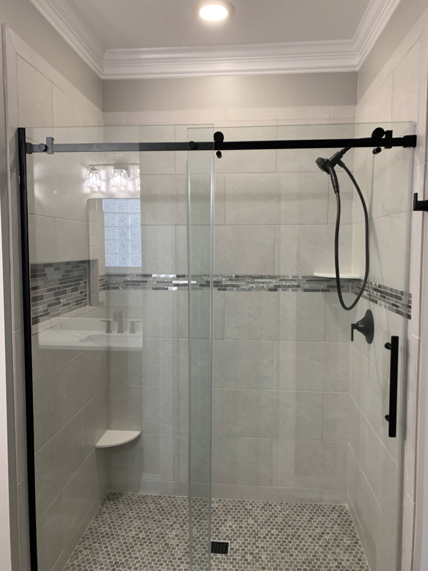Bathroom remodel, Raleigh NC. Custom tile shower with mosaic accent strip, frameless glass door.