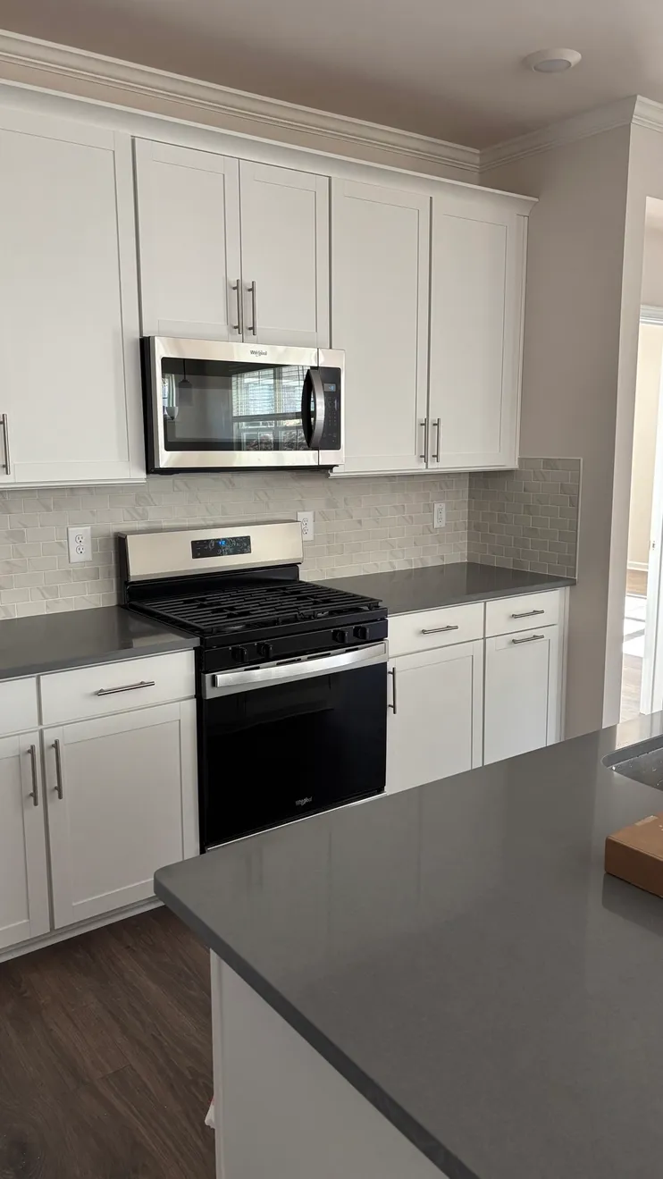 Cabinet and kitchen remodel, Mebane NC. White shaker cabinets, gray quartz countertop, tile backsplash.